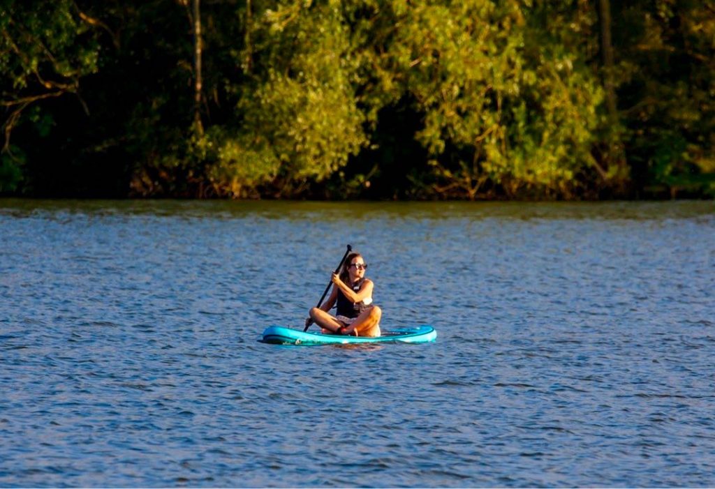 SU woman is sitting on her SUP Board