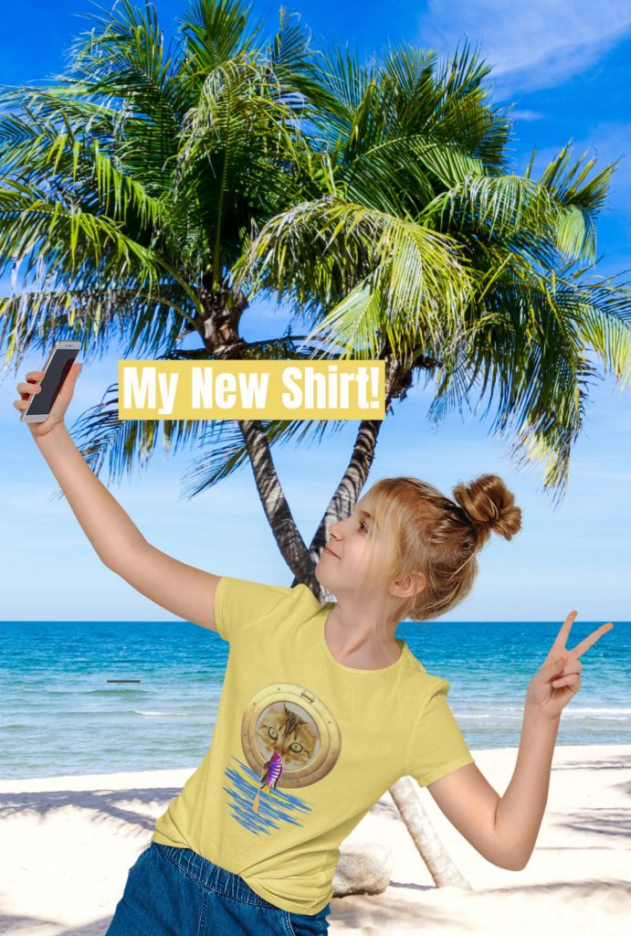 Mädchen macht Selfie am Strand mit neuem T-Shirt. Lustige niedliche Katze und Fisch auf SUP Board Geschenkidee Geschenk
