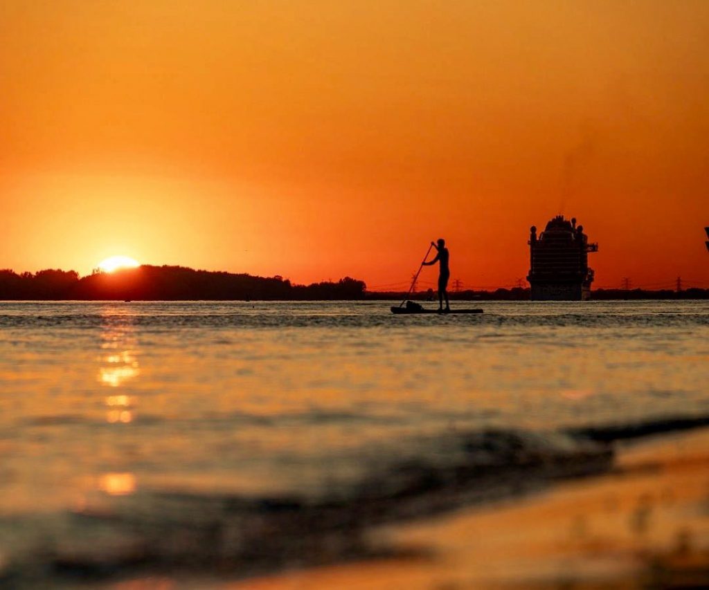 Toller Sonnenuntergang und Stand Up Paddle Paddeln Mann