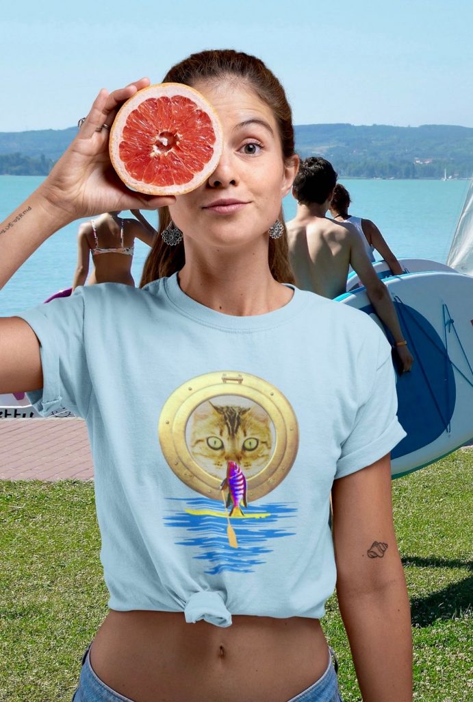 Woman with fruit in hand and funny t-shirt with cute cat and paddleboarding fish on SUP board tshirt gift idea present